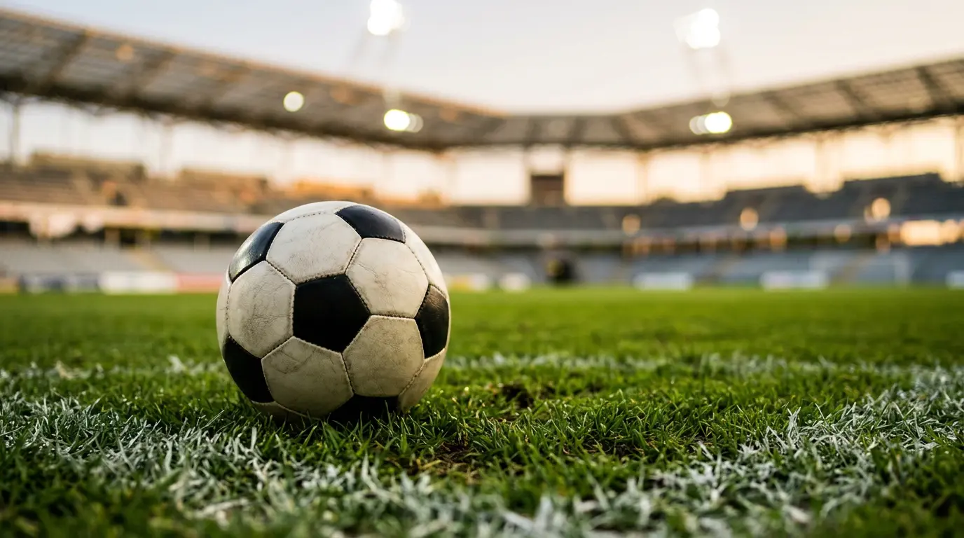 Detail fotbalového míče na trávníku stadionu před výkopem